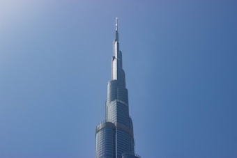 A tall, modern skyscraper with a sleek, tiered design reaching into a clear blue sky.