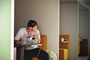 man wearing white top using MacBook