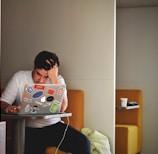 man wearing white top using MacBook