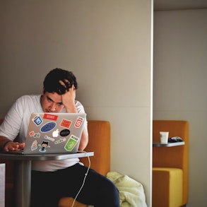 man wearing white top using MacBook