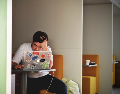 man wearing white top using MacBook