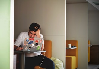 man wearing white top using MacBook