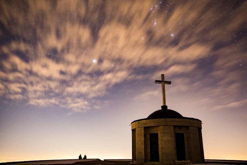 푸른 하늘 아래 십자가 마무리가 있는 벽돌 대성당의 실루엣