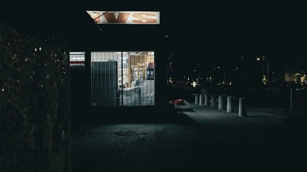 A small business storefront in the Bahamas featuring security alarms and well-lit entrances at dusk.