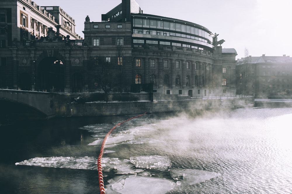 edificio in cemento grigio vicino allo specchio d'acqua