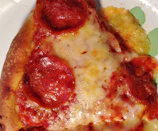 Close-up of a sizzling pepperoni pizza with bubbling cheese and fresh basil.