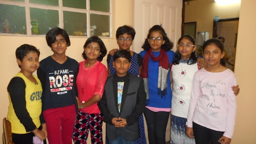 Children dressed in trendy outfits posing in natural light.