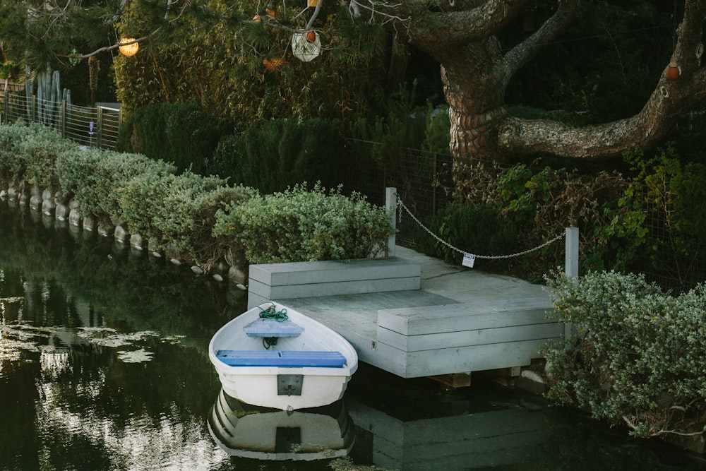 white boat docked near the wooden platform