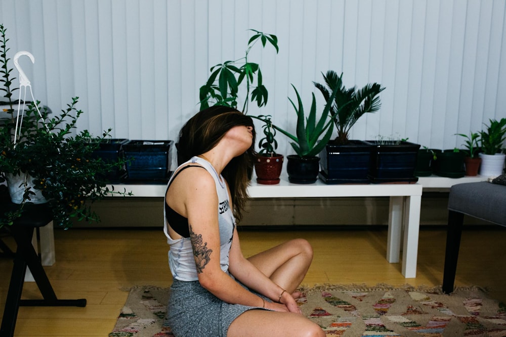 woman sitting on area rug near table