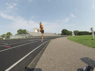 Athlete stretching before a morning run on a sunlit track.
