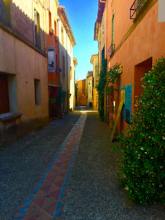 A charming narrow street in Toledo with colorful buildings and cobblestone pavement bathed in warm sunlight.