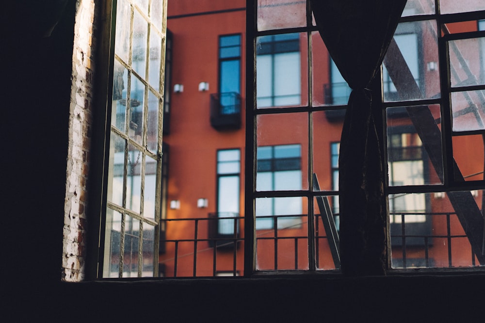 photo minimaliste d’une fenêtre en verre avec vue sur le bâtiment