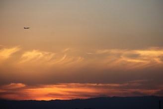 A sleek airplane soaring above the clouds during sunset, symbolizing smooth travel.