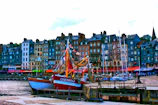 A vibrant port bustling with boats and colorful buildings along the waterfront.
