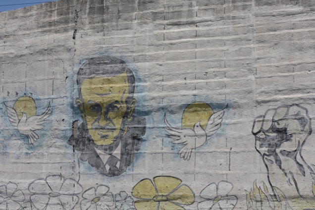 Portrait of Carlos Fonseca in a historical setting with revolutionary symbols.