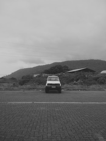 A light commercial vehicle parked in an industrial yard with clear skies