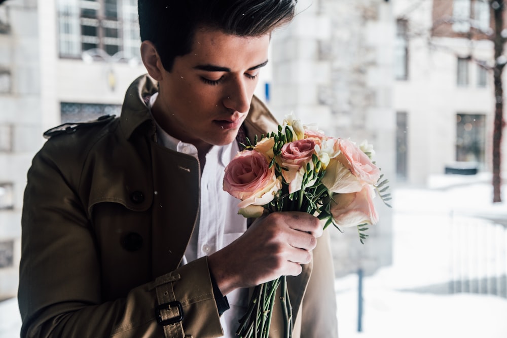 man holding pink roses