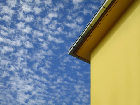 A freshly restored commercial building with crisp siding and new roofing under a bright sky.