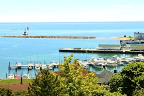 Wide view of the six-acre park-like marina site with calm waters and distant tree-lined shore.