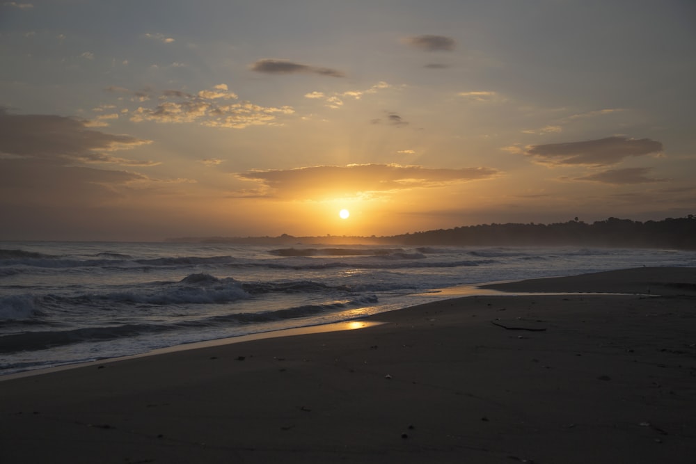 Ondas do mar caindo na costa durante o pôr do sol