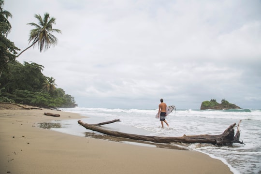 woman in blue bikini walking on beach during daytime in Puerto Viejo de Talamanca Costa Rica