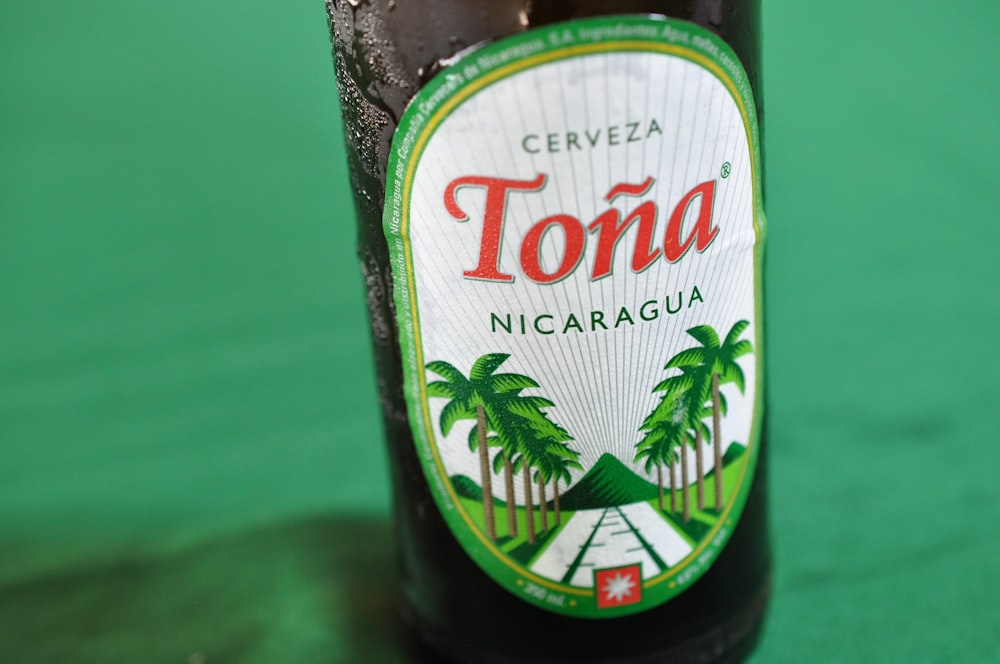 Bouteille Cerveza Tona nicaragua sur surface verte