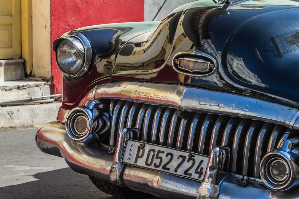 Veículo preto clássico estacionado além de prédio durante o dia