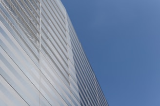 A sleek commercial office building rising against a clear sky.