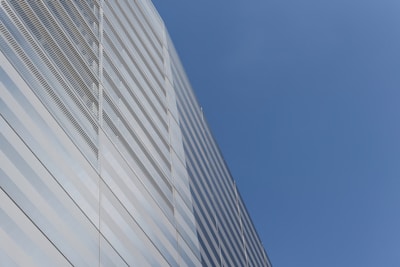 A sleek commercial office building rising against a clear sky.