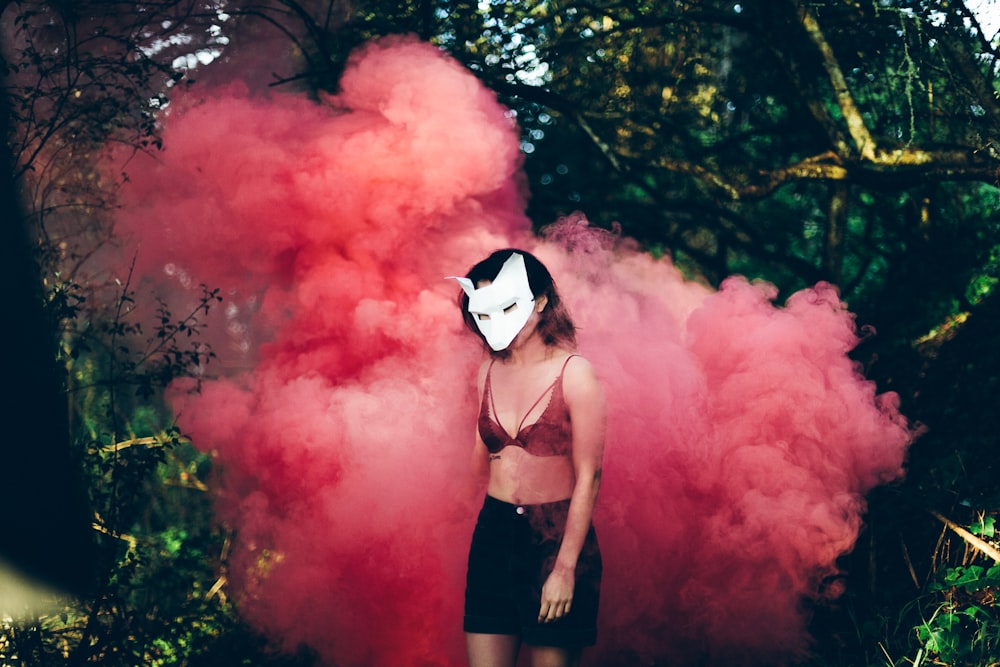 Mujer de pie frente al humo rojo
