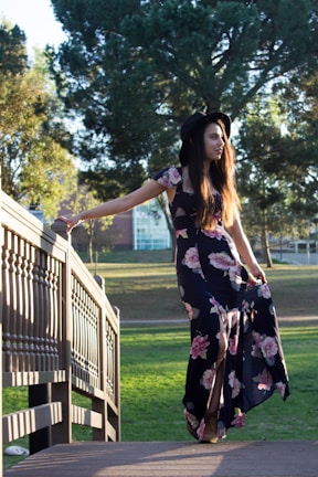 A stylish woman wearing a flowing dress in a park.