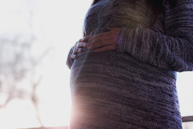 A gentle midwife comforting a pregnant woman in a cozy, softly lit room.