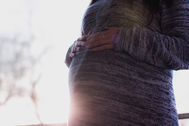 A caring midwife softly talking to a mother-to-be in a cozy clinic room.
