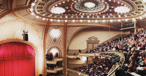 Audience applauding warmly in a historic opera house.