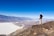 A happy traveler standing on the vast white salt flats of Salar de Uyuni under a clear blue sky.