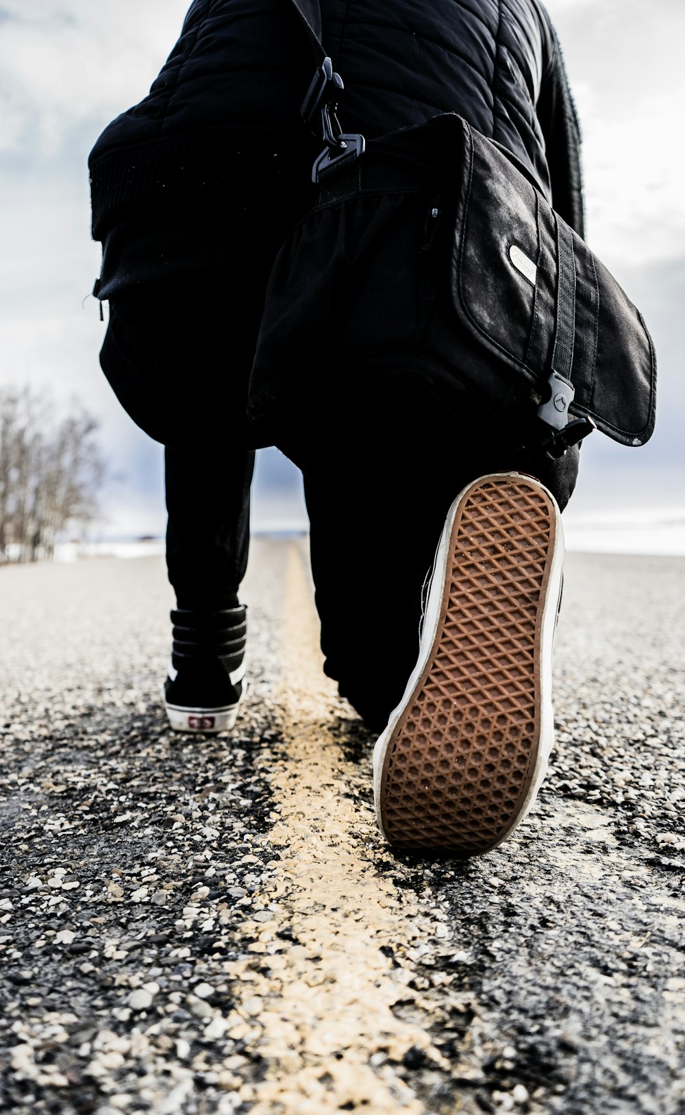 person kneeling right leg on road during daytime