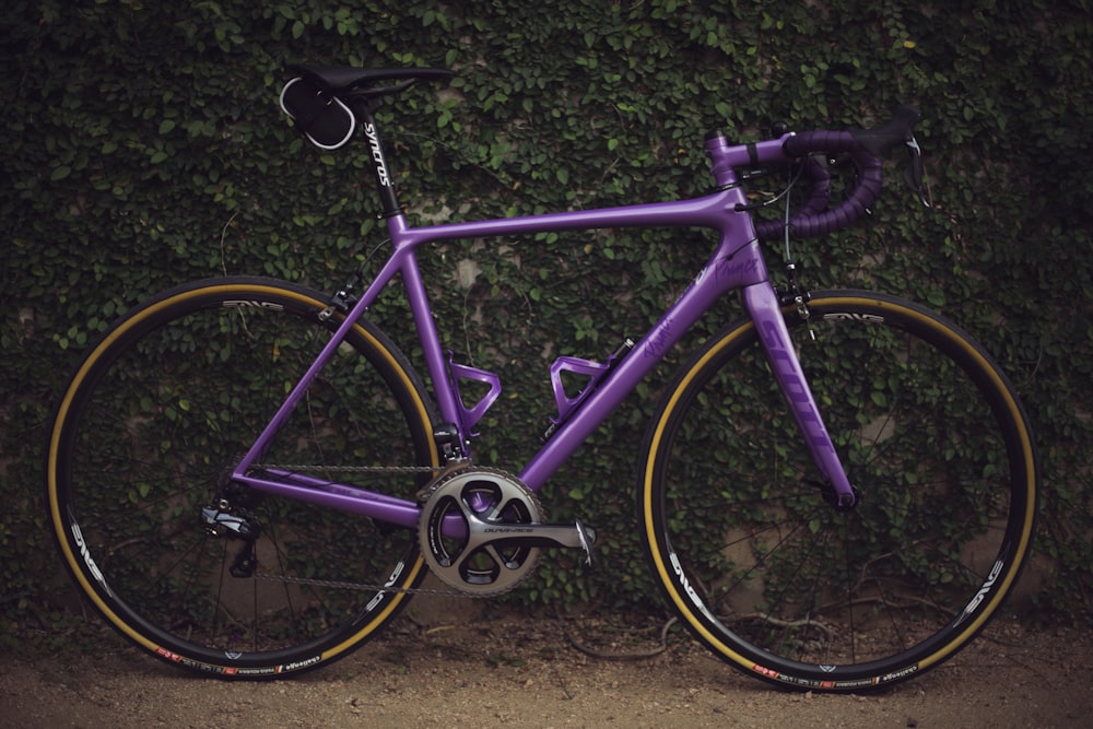 vélo de route violet près du mur