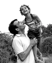A cheerful dad and child roadside, thumbs up, ready for a hitchhiking journey.