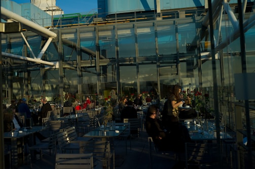 Outdoor restaurant seating area enclosed with transparent automatic glass walls.