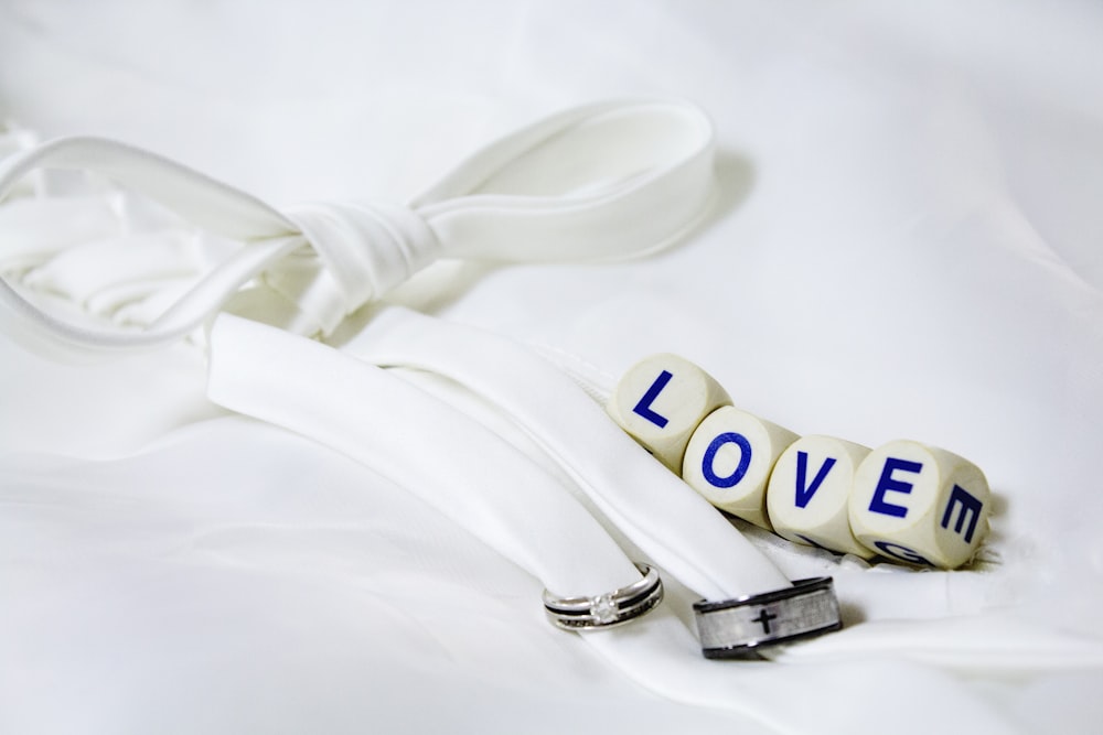 White material tied in a bow, with little cubes that say "Love."