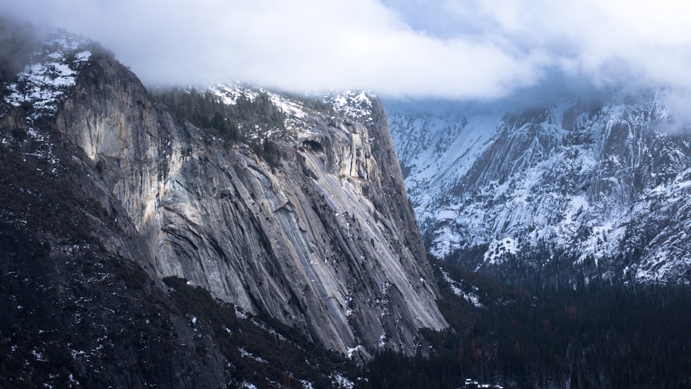 photo of snow capped mountain under white clouds