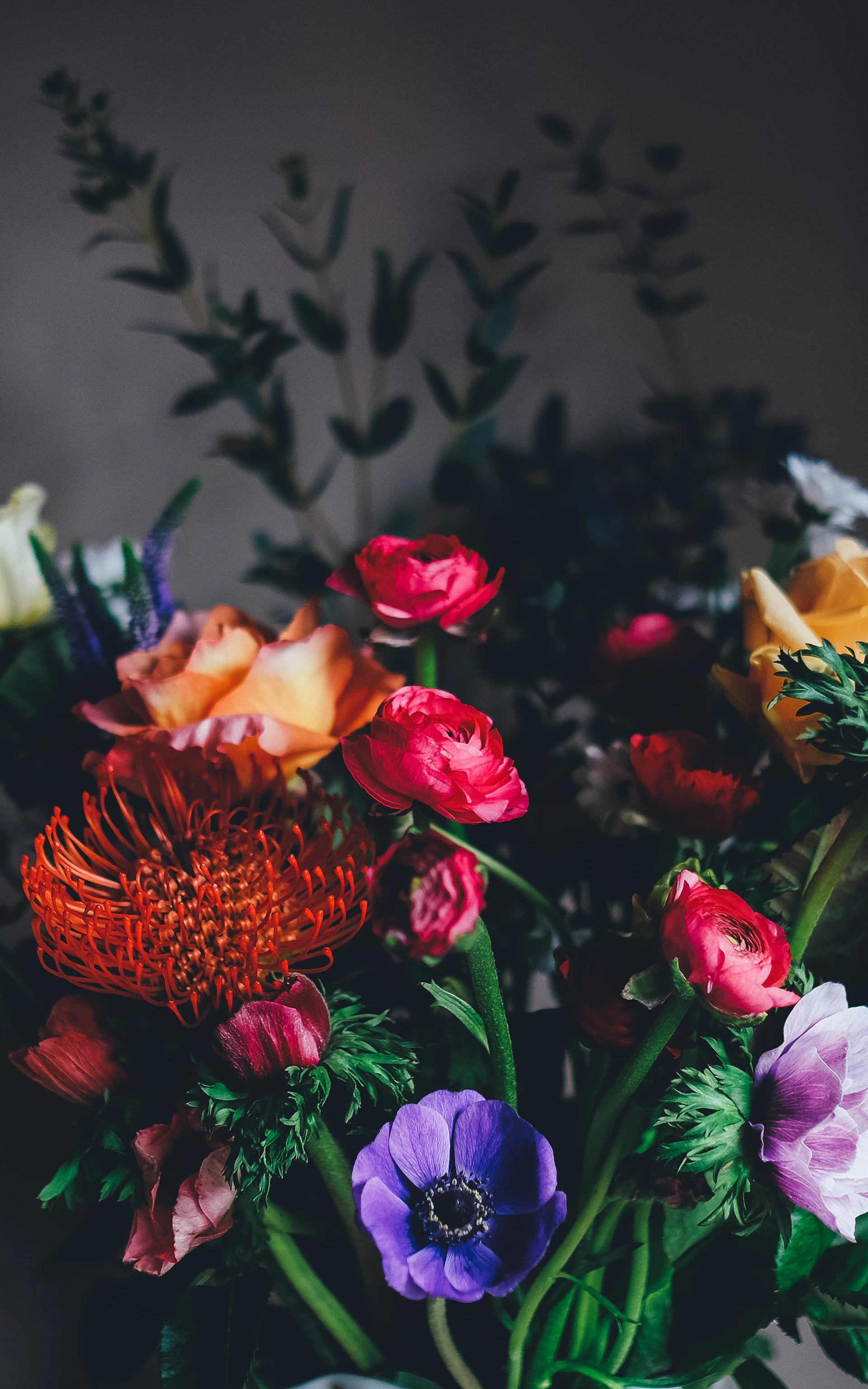 Hands presenting a freshly wrapped bouquet at the doorstep