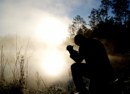 silhouette of kneeling man