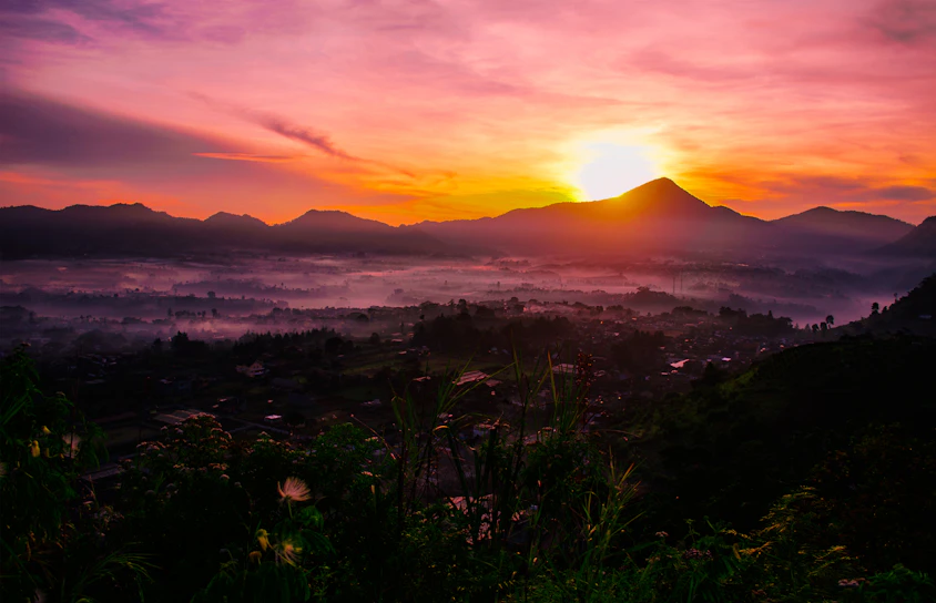 A vibrant sunrise over misty mountain peaks during a trekking expedition.