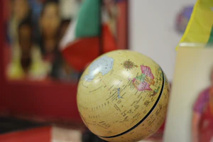 A globe surrounded by speech bubbles showing greetings in different languages.