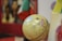 A globe displaying geographical details is placed in the foreground. The background is blurred, showing vibrant colors and indistinct objects. Flags are partially visible to the right, adding a multicultural aspect.