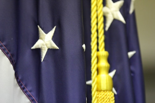 Close-up of a creamy pima cotton baby blanket with delicate gold embroidery celebrating 250 years of U.S. independence.