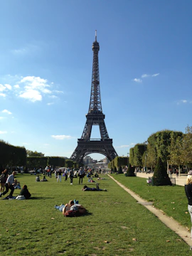 Tourists enjoying a sunny day in a French city with landmarks.