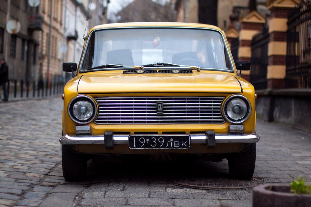 yellow car between building