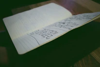 A thoughtful high school student writing notes surrounded by colorful stationery and soft lighting.